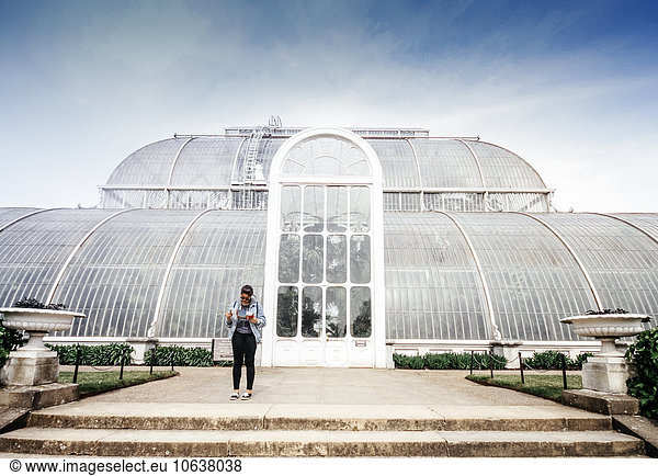 Full length of woman standing outside greenhouse