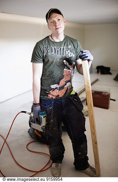 Full length portrait of confident carpenter standing at site