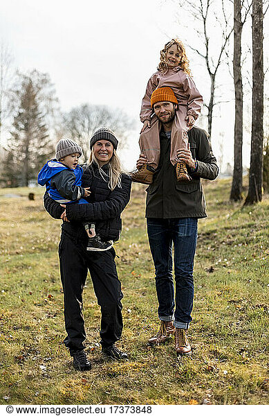 Full length portrait of family standing together at park