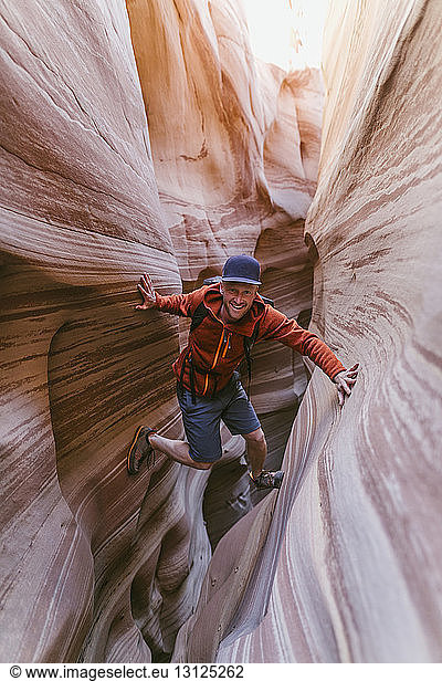 Full length portrait of hiker canyoneering amidst narrow canyons