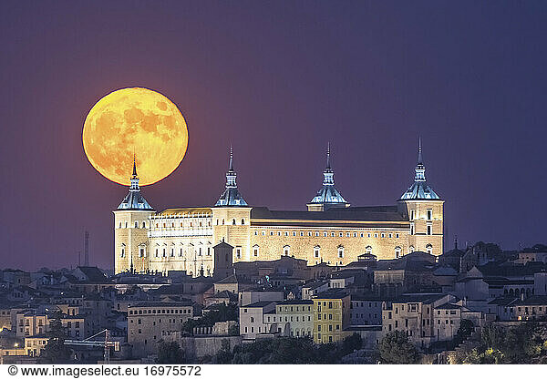 Full moon over historical castle  Alcazar of Toledo old town.