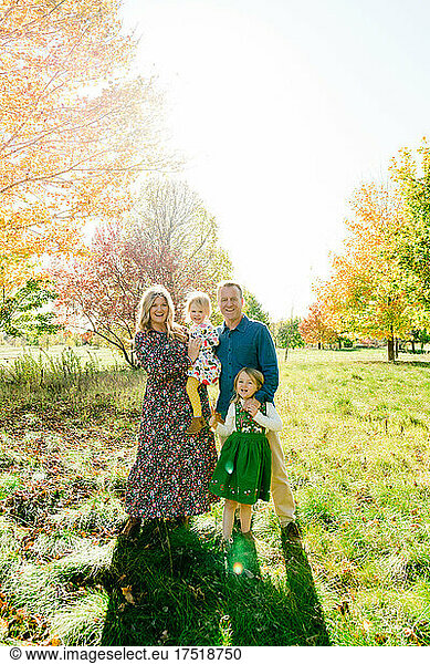 Fun smiling portrait of a family of four outdoors