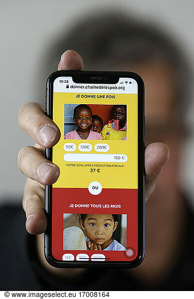 Fundraising on a smartphone for the Chain of Hope. French NGO. France.