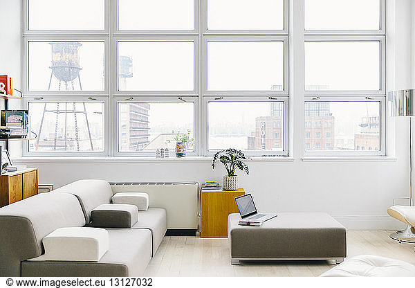 Furniture on hardwood floor against windows in modern startup office