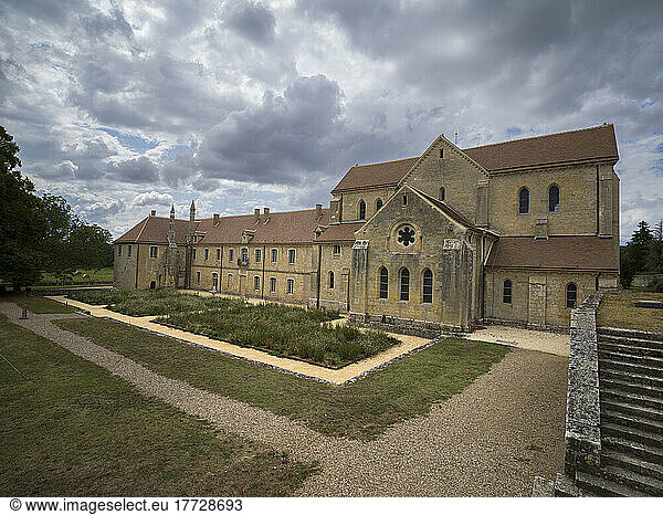 Garden and the exterior of the ancient Noirlac Abbey on a cloudy day  Cher  Centre-Val de Loire  France  Europe
