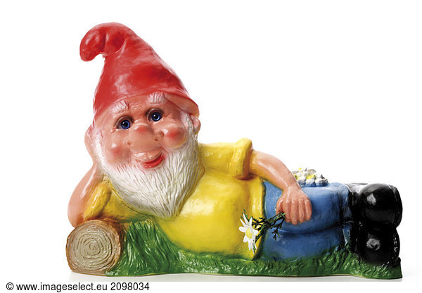 Garden gnome lying on meadow  close-up