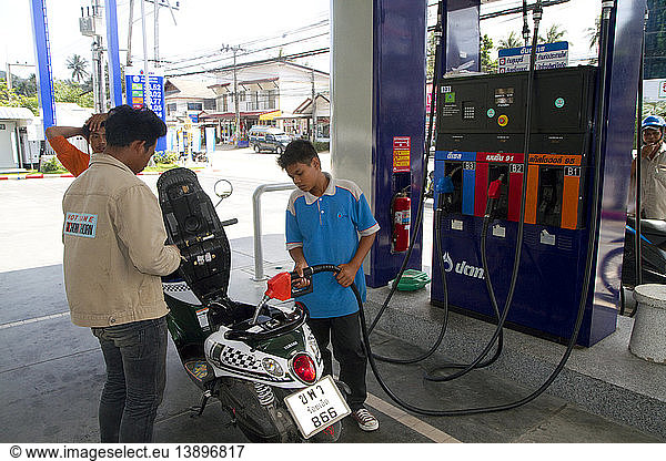 Gas Station Attendant Filling up a Motor Scooter