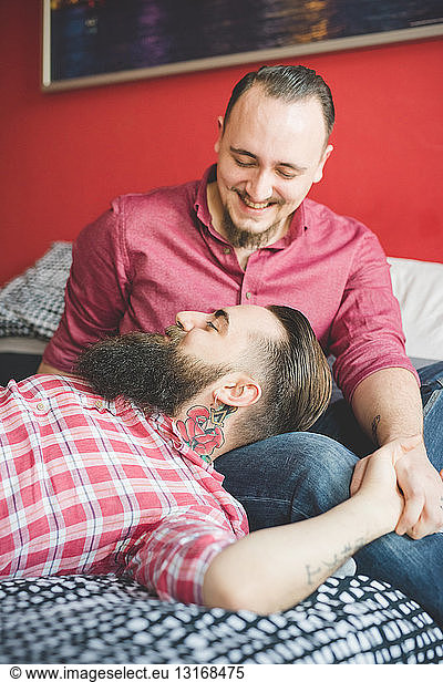 Gay couple chatting in bedroom