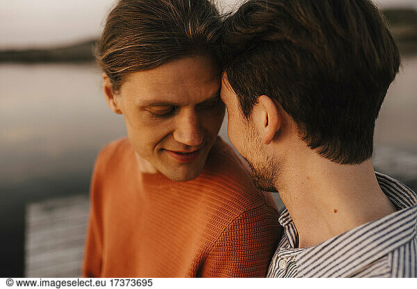 Gay couple doing romance at lakeshore
