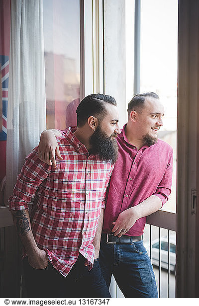 Gay couple looking out of window