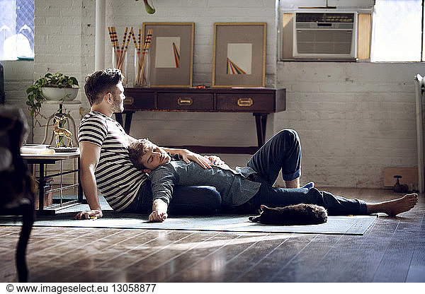 Gay couple relaxing on living room at home
