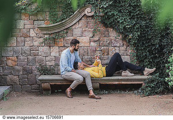 Gay couple relaxing together on a bench