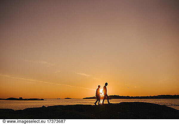 Gay couple spending leisure time while walking during sunset