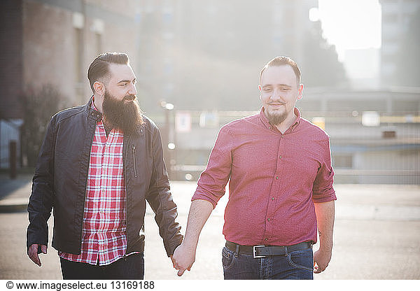 Gay couple walking hand in hand on street