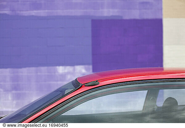Gebäude außen  bemalte Wand  lila bemalte Blöcke und rotes Auto.