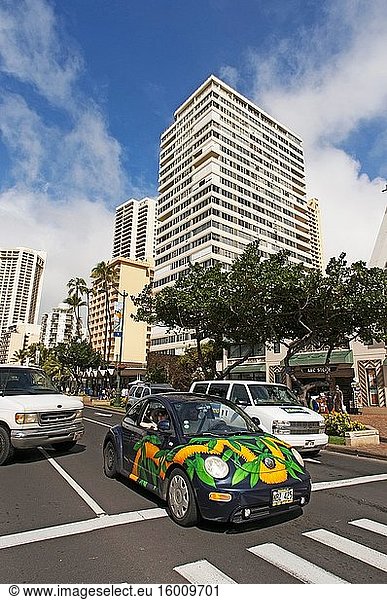 Gebäude und Hotels in Waikiki Beach. Kalakaua Avenue. O'ahu. Hawaii. Das weltberühmte Viertel Waikiki liegt an der Südküste von Honolulu und war einst ein Spielplatz für die hawaiianischen Könige. Waikiki  auf Hawaii als sprudelnde Gewässer bekannt  wurde der Welt vorgestellt  als 1901 das erste Hotel  das Moana Surfrider  an seinen Ufern gebaut wurde. Heute ist Waikiki das wichtigste Hotel- und Feriengebiet Oahus und ein pulsierender Treffpunkt für Besucher aus aller Welt. Entlang des Hauptstreifens der Kalakaua Avenue finden Sie erstklassige Einkaufsmöglichkeiten  Restaurants  Unterhaltungsangebote  Aktivitäten und Resorts. Waikiki ist vor allem für seine Strände bekannt  und jedes Zimmer ist nur zwei oder drei Blocks vom Meer entfernt. Mit Leahi (Diamond Head) als Kulisse sind die ruhigen Gewässer von Waikiki wie geschaffen für eine Surfstunde. Der legendäre hawaiianische Wassersportler Duke Kahanamoku wuchs mit dem Surfen in den Wellen von Waikiki auf. Dieser olympische Goldmedaillengewinner im Schwimmen brachte den Besuchern um die Jahrhundertwende das Surfen bei und wurde später als ? Der Vater des modernen Surfens. Heute führen die Waikiki Beach Boys das Vermächtnis von Duke fort  indem sie Besuchern das Surfen und Kanufahren beibringen  und die Duke Kahanamoku-Statue ist zu einem Wahrzeichen von Waikiki geworden.