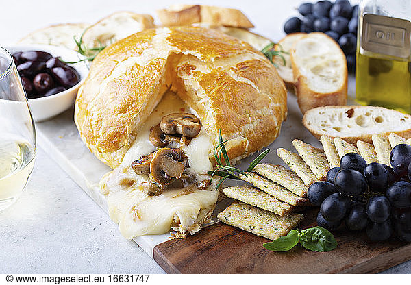 Gebackener Brie im Blätterteig mit Pilzen  Brot und Crackern auf Brett