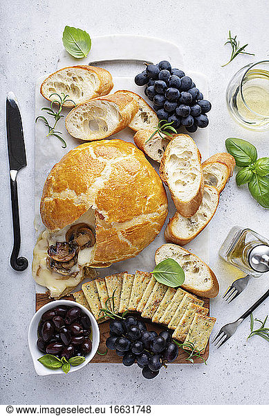 Gebackener Brie im Blätterteig mit Pilzen Brot und Crackern auf Brett