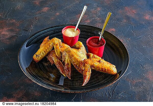 Gebratene Hähnchenflügel mit Ketchup und Mayonnaise