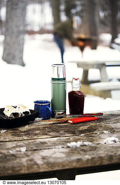 Gegenstände auf Holztisch im verschneiten Wald