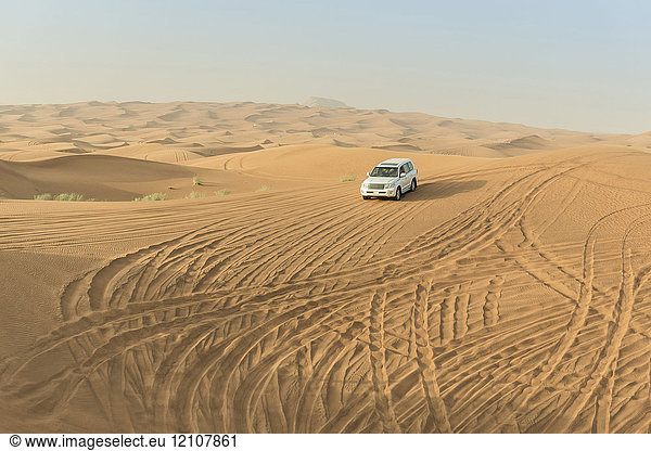 Geländewagen fährt durch Wüstendünen  Dubai  Vereinigte Arabische Emirate