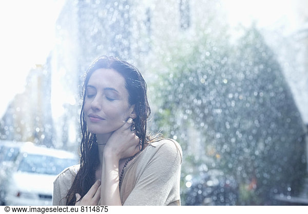Gelassene Frau im Regen stehend