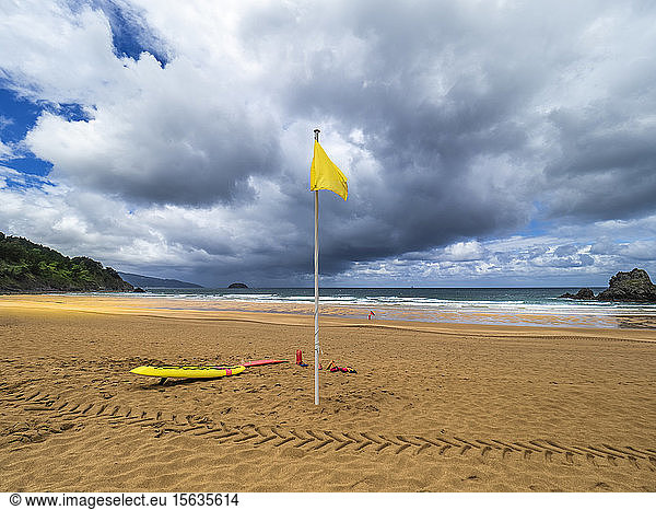 Gelbe Flagge am Strand von Laga vor bewölktem Himmel  spanisches Baskenland  Spanien