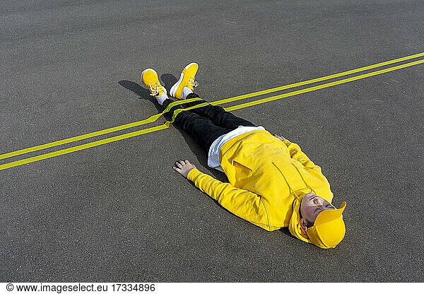 Gelbe Markierung über dem Bein eines auf der Straße liegenden Jungen