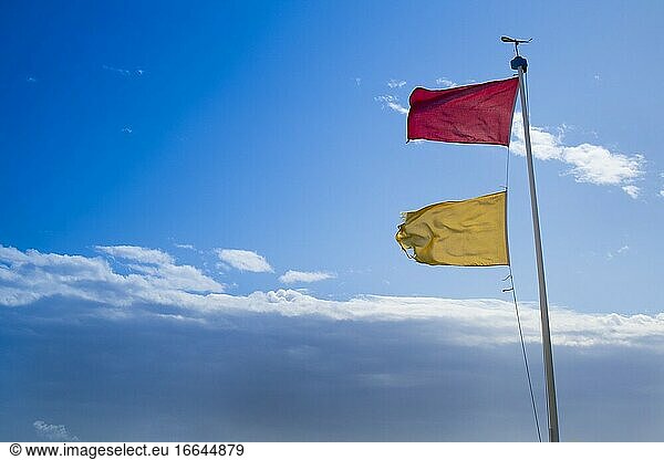 Gelbe und rote Flaggen zur Kennzeichnung von Gefahren im Meer am Strand von Viareggio in der Toskana Italien.