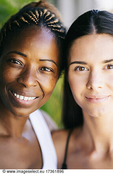 Gemeinsam lächelnde multiethnische Freundinnen