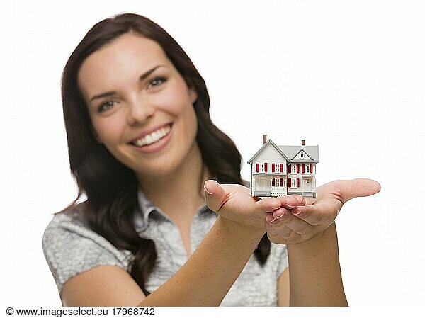 Gemischtrassige Frau hält kleines Haus vor weißem Hintergrund  Fokus liegt auf dem Haus