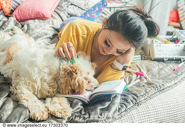 Gen Z writing in her journal with her pet dog