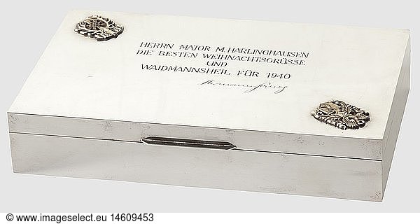 Generalleutnant Martin Harlinghausen - a presentation case from Hermann GÃ¶ring  Silver cigarette case  a 1940 Christmas gift from Hermann GÃ¶ring. Rectangular in shape  the inner surfaces and base in wood. On the cover a silver gilt family coat of arms of Hermann GÃ¶ring and a device of the German Hunting Association with a green precious stone setting  at the centre the engraved inscription 'Herrn Major Harlinghausen die besten WeihnachtsgrÃ¼sse und Waidmannsheil fÃ¼r 1940 - Hermann GÃ¶ring' (To Major Harlinghausen the best Christmas greetings and a huntsman's salute for 1940 - Hermann GÃ¶ring). On the base frame is a German fineness mark '800' and number stamping. Height 3 5 cm  width 18 cm  depth 11 cm. Weight 320 g. A typical gift from Hermann GÃ¶ring to one of his best combat pilots  historic  historical  1930s  20th century  Air Force  branch of service  branches of service  armed service  armed services  military  militaria  air forces  object  objects  stills  clipping  clippings  cut out  cut-out  cut-outs  fine arts  art  art object  art objects  artful  precious  collectible  collector's item  collectibles  collector's items  rarity  rarities