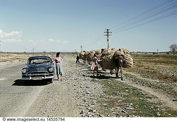 Geo. hist.  Iran  StraÃŸenszene  Frau und MÃ¤dchen mit Opel Rekord am StraÃŸenrand beobachten Bauer mit Lasttieren  1955
