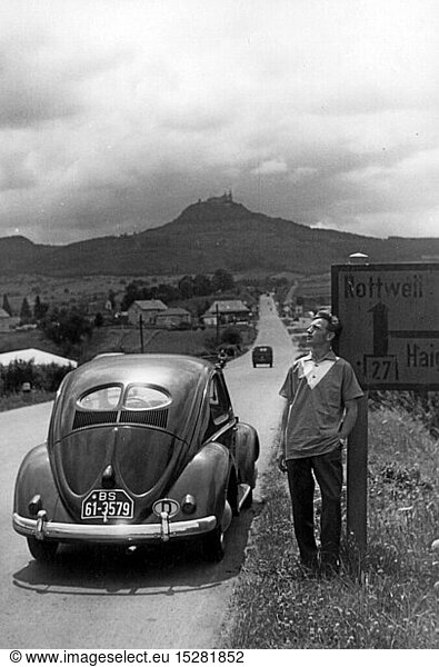 geography / travel  Germany  Baden-Wuerttemberg  transport / transportation  man with VW beetle having rest in visual range of the Hohenzollern castle  1948 - 1956  20th century  1940s  1950s  half length  standing  break  breaks  road sign  road signs  guidepost  fingerpost  signpost  sign  signposts  signs  signboard  signboards  roadside  interstate road 27  landscape  landscapes  hill  hills  horizon  car  cars  Volkswagen  VW beetle  VW type 1  travels  travelling  traveling  travel  excursion  outing  short trip  excursions  outings  short trips  tourism  touristic  Southern Germany  the South of Germany  Germany  Central Europe  Europe  road  roads  land route  traffic route  traffic routes  transport  transportation  mobility  visibility  wideness  view  views  distance  distances  40s  50s  Baden-Wuerttemberg  Baden Wuerttemberg  Wuertemberg  Baden-Wurtemberg  Wurtemberg  Wurttemberg  Baden-Wuertemberg  Baden-WÃ¼rttemberg  WÃ¼rttemberg  man  men  visual range  beyond the range of vision  outside the range of vision  within sight  within the range of vision  castle  castles  historic  historical  man  men  male  people
