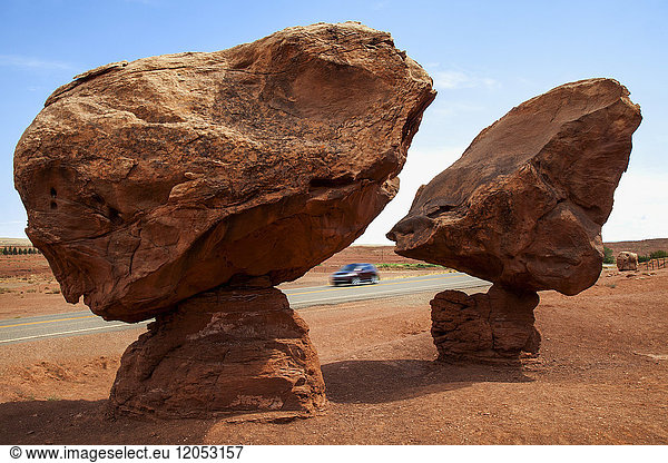 Geologische Formation Balancing Rocks in der Nähe von Lee's Ferry  Az auf indianischem Land  im Hochsommer mit einem Auto auf dem Highway und blauem Himmel dahinter; Arizona  Vereinigte Staaten von Amerika