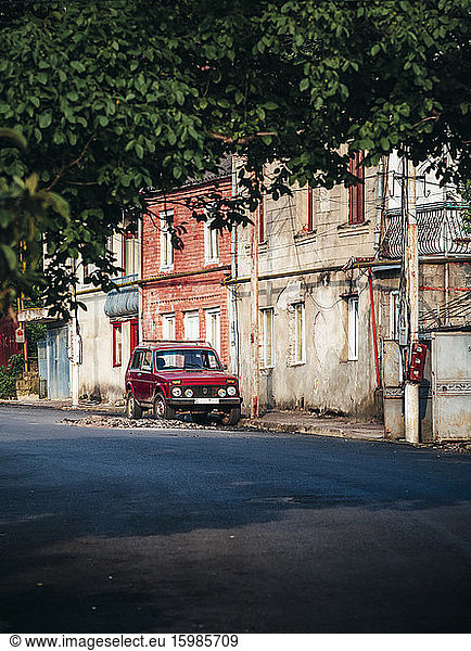 Georgia  Imereti  Kutaisi  Car parked at old buildings