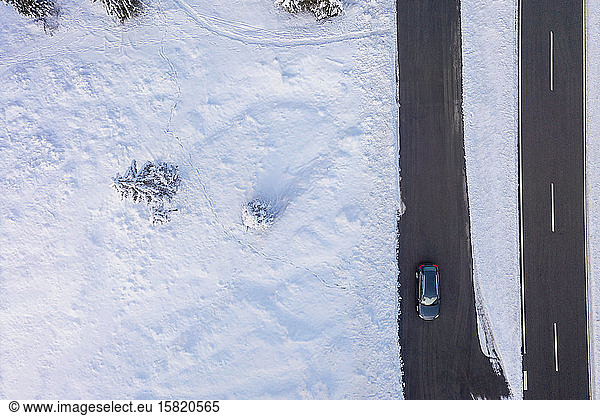 Germany,  Bavaria,  Aerial view of car driving along country road in winter