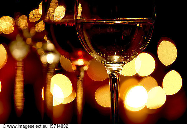 Germany,  Glasses of red wine with Christmas lights in background