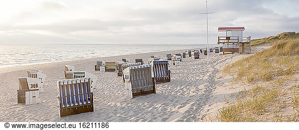 Germany,  View of empty beach with roofed wicker beach chairs on Sylt island