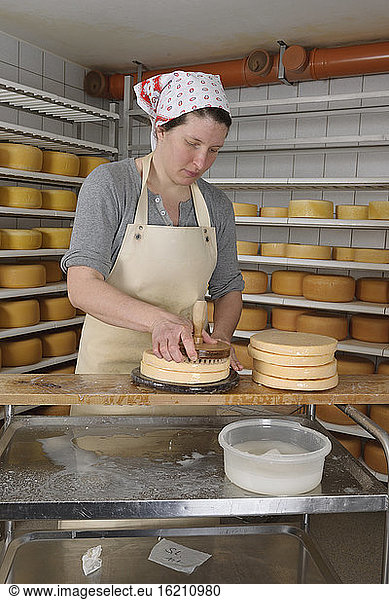 Germany  Baden Wuerttemberg  Mid adult woman sprinkling salt water on cheese