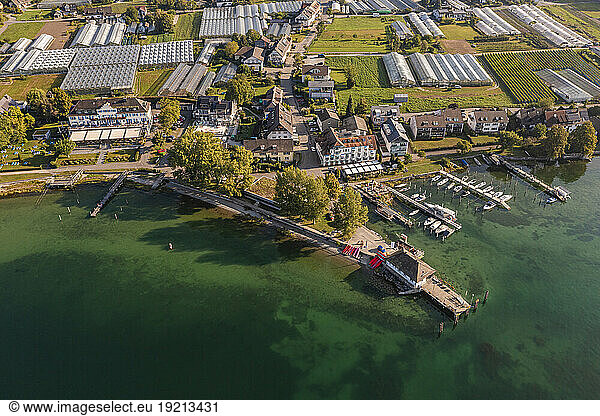 Germany  Baden-Wurttemberg  Aerial view of jetties on shore of Reichenau island with greenhouses in background