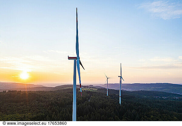 Germany  Baden-Wurttemberg  Aerial view of wind farm turbines in Schurwald range at sunset