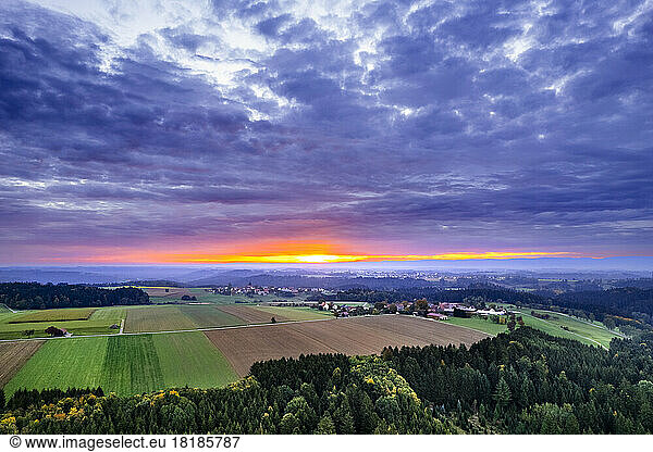 Germany  Baden-Wurttemberg  Dramatic clouds over fields in Swabian-Franconian Forest at sunrise