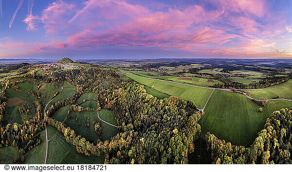 Germany  Baden-Wurttemberg  Drone view of autumn grove at moody dusk with Hohenstaufen mountain in distant background