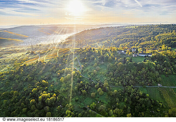 Germany  Baden-Wurttemberg  Drone view of sun rising over autumn landscape of Remstal valley