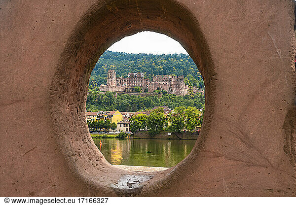Germany  Baden-Wurttemberg  Heidelberg  Heidelberg Castle seen through circular hole of Liebesstein sandstone
