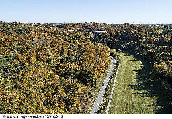 Germany  Baden-Wurttemberg  Heidenheim an der Brenz  Drone view of highway stretching along edge of autumn forest