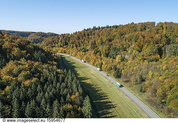 Germany  Baden-Wurttemberg  Heidenheim an der Brenz  Drone view of traffic on highway stretching along edge of autumn forest