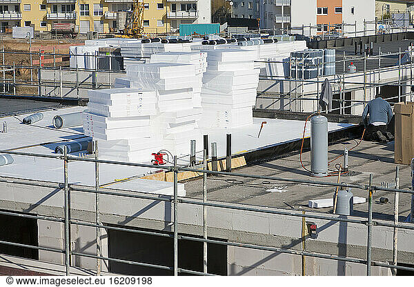 Germany  Baden Wurttemberg  Ludwigsburg  Construction worker insulating flat roof
